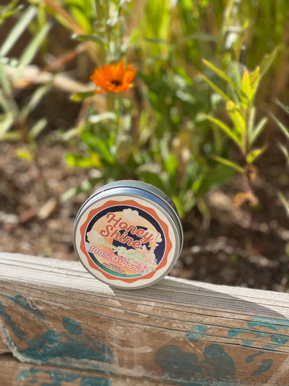 Honeyshine Mama’s Lullaby Body Butter displayed outdoors with calendula flowers