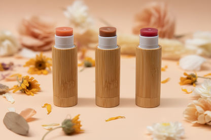 Honeyshine tinted lip shine tubes in natural bamboo packaging with floral background